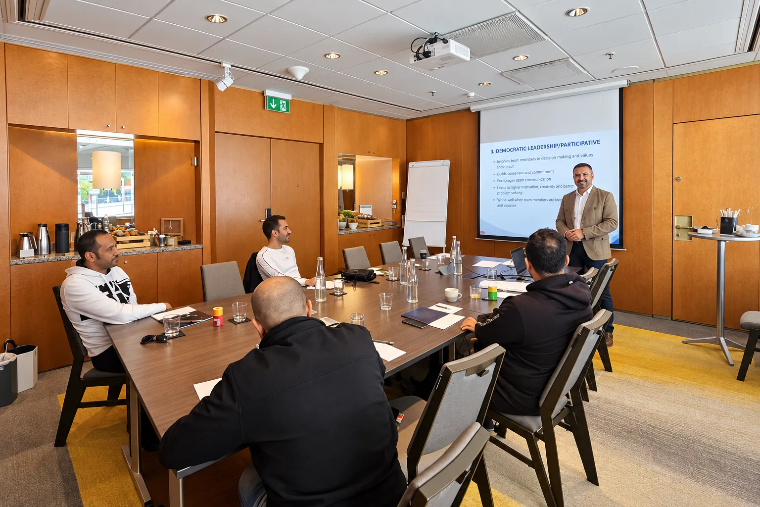 Trainer presenting to delegates in a wood-panelled training room